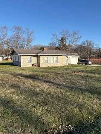 a big yard with trees in front of it