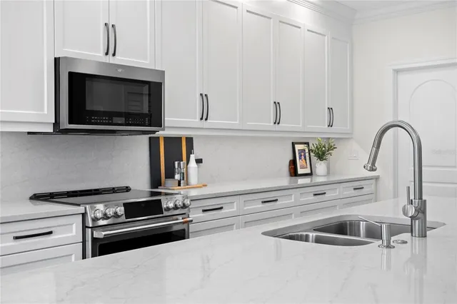 a kitchen with kitchen island granite countertop a sink a counter space appliances and cabinets