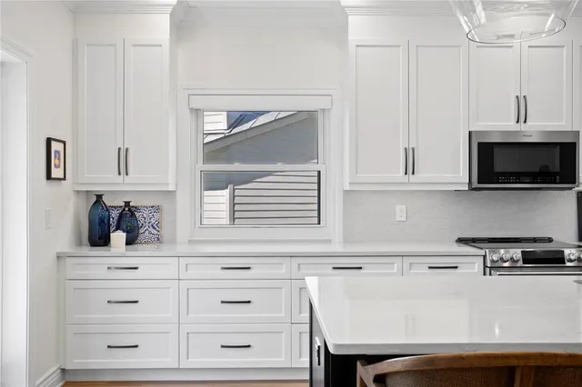 a kitchen with a dining table chairs sink and microwave
