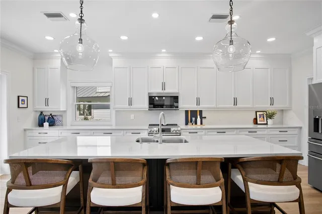 a view of a dining room and livingroom with furniture wooden floor a chandelier