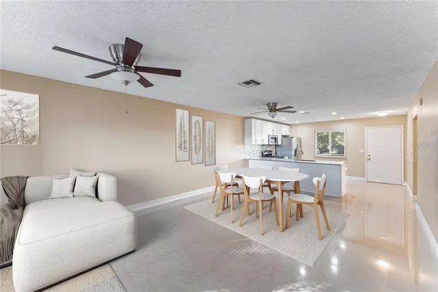 a living room with furniture a dining table and kitchen view