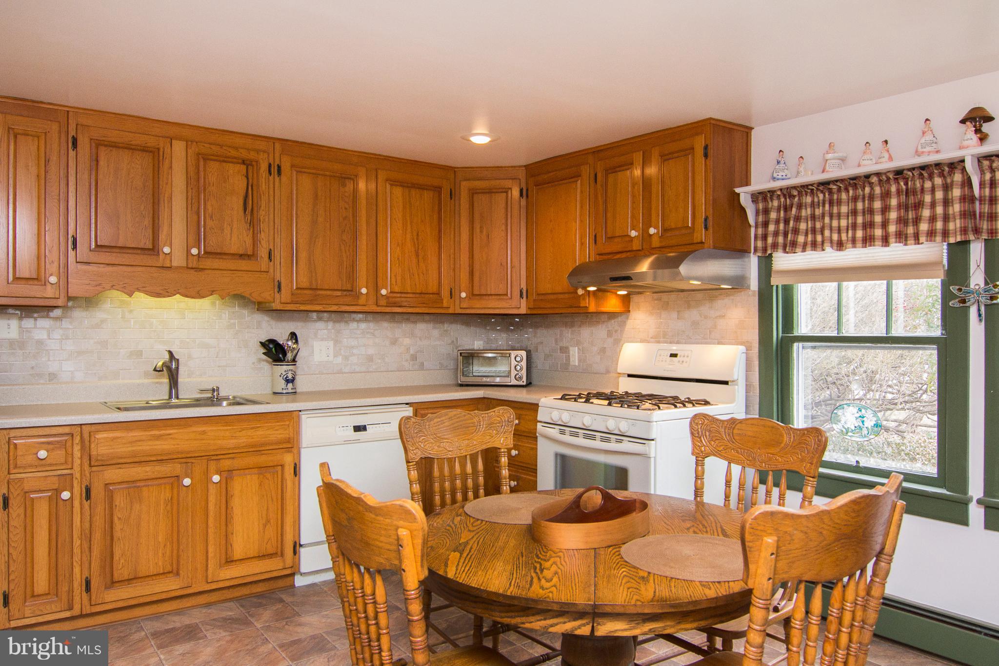 3358 Uniontown Road Westminster, MD 21158 - Photo 11 of 30 a kitchen with a stove a table and chairs in it