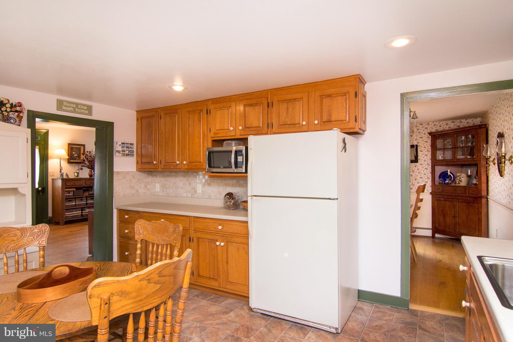 3358 Uniontown Road Westminster, MD 21158 - Photo 9 of 30 a kitchen with a refrigerator a counter top space and cabinets