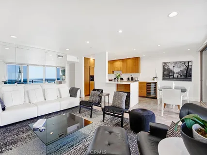 a living room with furniture kitchen view and a large window