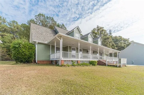 a front view of a house with a yard and potted plants