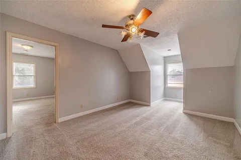 a view of an empty room and a ceiling fan