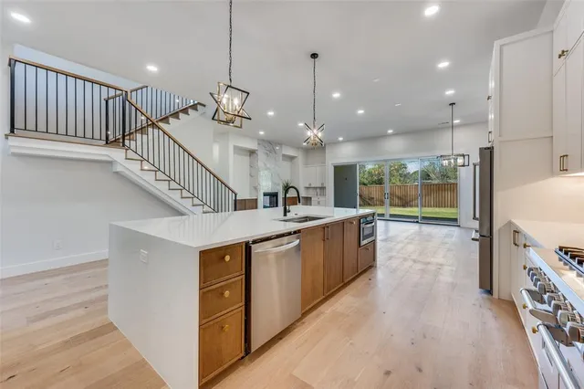 a open kitchen with kitchen island a stove a sink and a refrigerator
