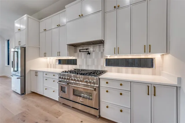 a kitchen with cabinets appliances and wooden floor