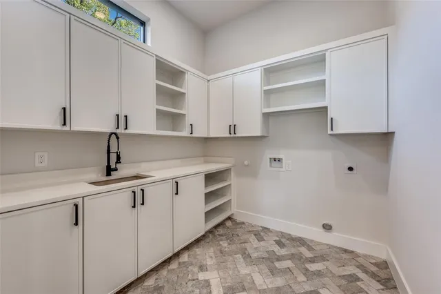 a kitchen with white cabinets and sink
