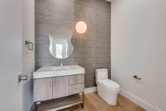 a bathroom with a toilet sink vanity and mirror