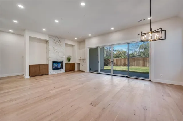 a view of empty room with wooden floor and fireplace