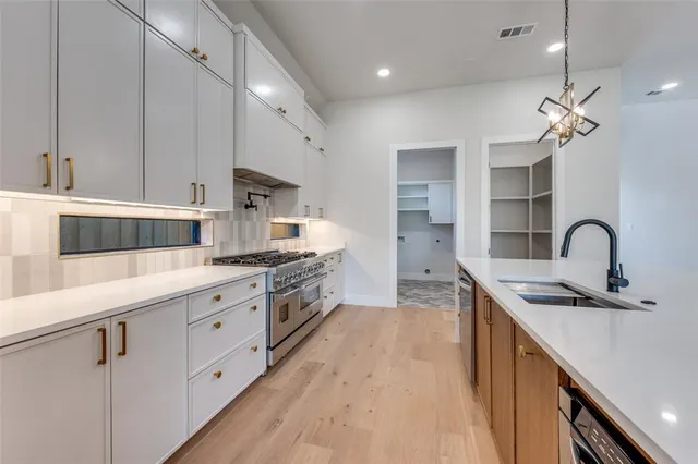 a kitchen with kitchen island granite countertop a sink stainless steel appliances and white cabinets
