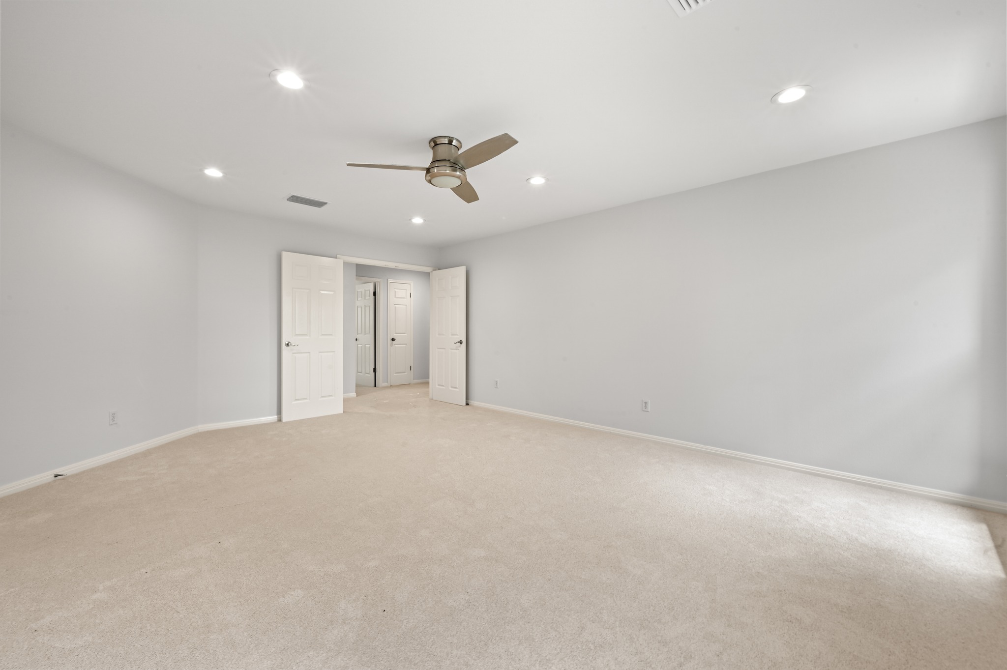 1107 Bowie Road Austin, TX 78733 - Photo 24 of 40 Recessed lighting and a modern ceiling fan illuminate this spacious room with plush carpeted flooring.