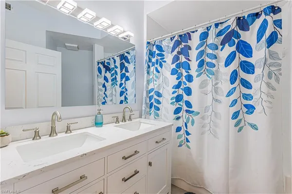 a bathroom with a sink mirror and shower curtain