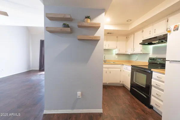 a kitchen with cabinets stainless steel appliances and wooden floor