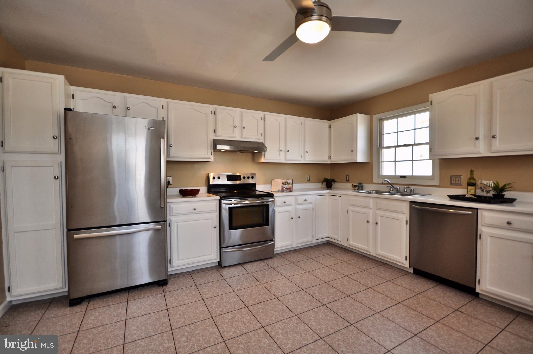 1200 Riverside Avenue Baltimore, MD 21230 - Photo 13 of 30 a kitchen with white cabinets stainless steel appliances and a window