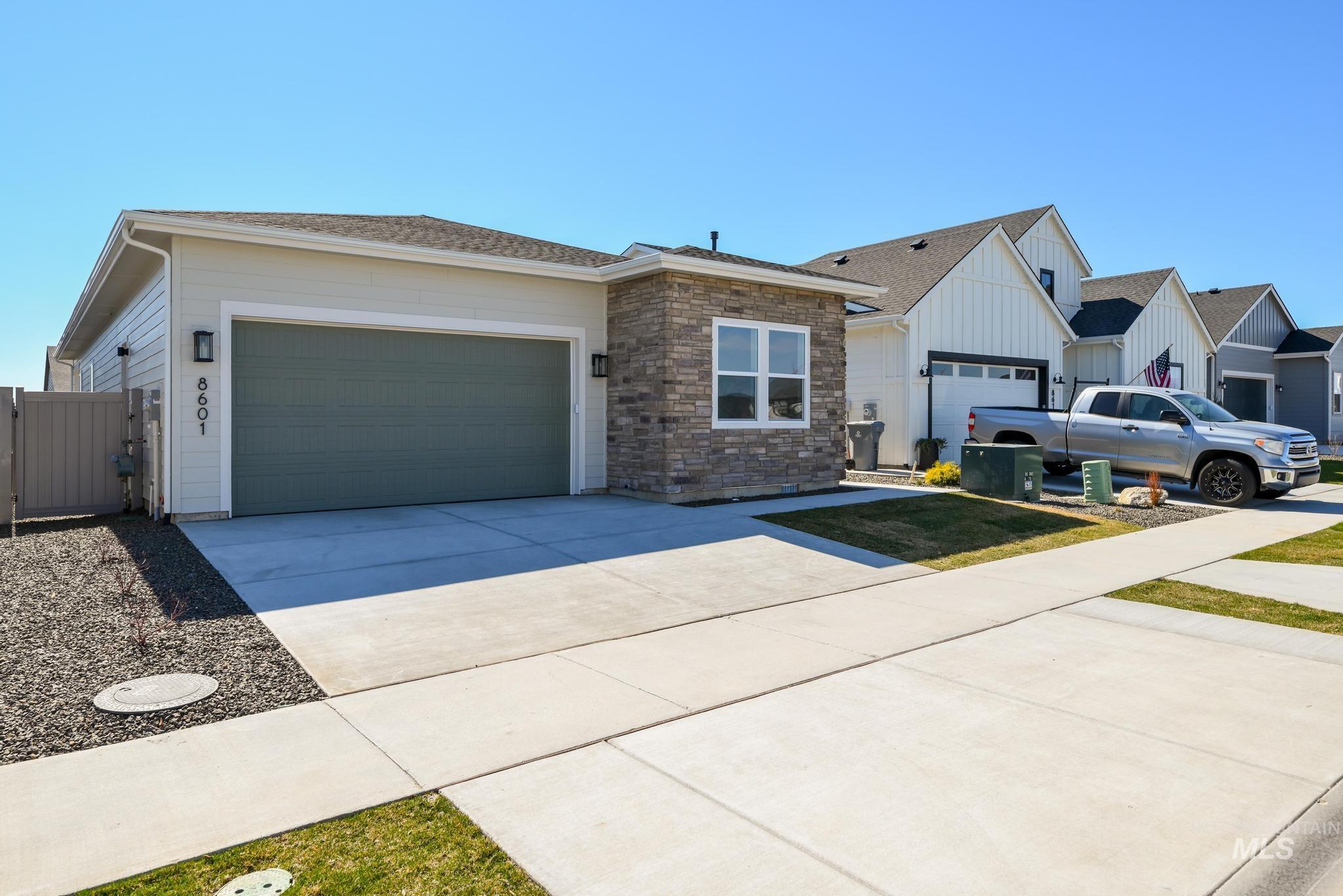 8601 West Stillmore Street Star, ID 83669 - Photo 1 of 1 View of front of house featuring an attached garage, concrete driveway, a gate, stone siding, and board and batten siding