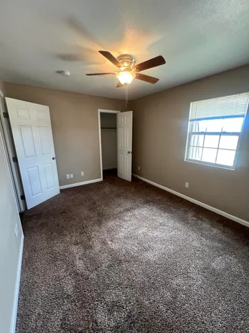 an empty room with windows and closet