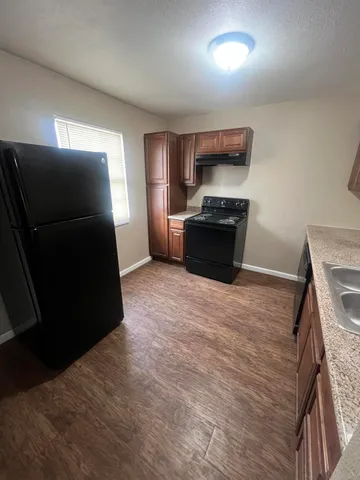 a kitchen with granite countertop a refrigerator and a stove