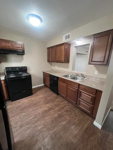 a kitchen with stainless steel appliances kitchen island granite countertop a stove a sink and a refrigerator