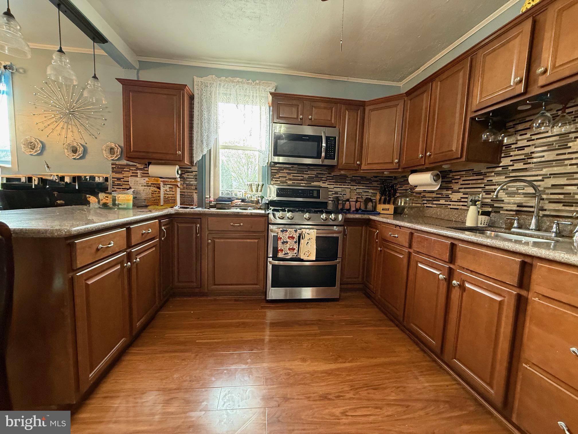 a kitchen with stainless steel appliances granite countertop wooden cabinets sink and stove top oven