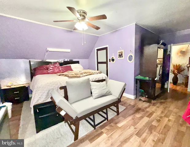 a bedroom with a bed a chandelier and dresser