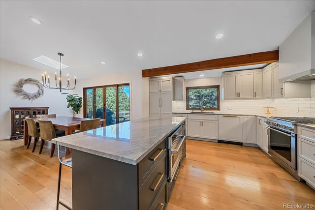 a kitchen with stainless steel appliances granite countertop a sink cabinets and wooden floor