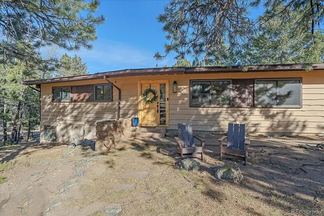 a view of a patio with table and chairs under an umbrella with a large tree