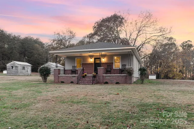 a view of a house with backyard and sitting area