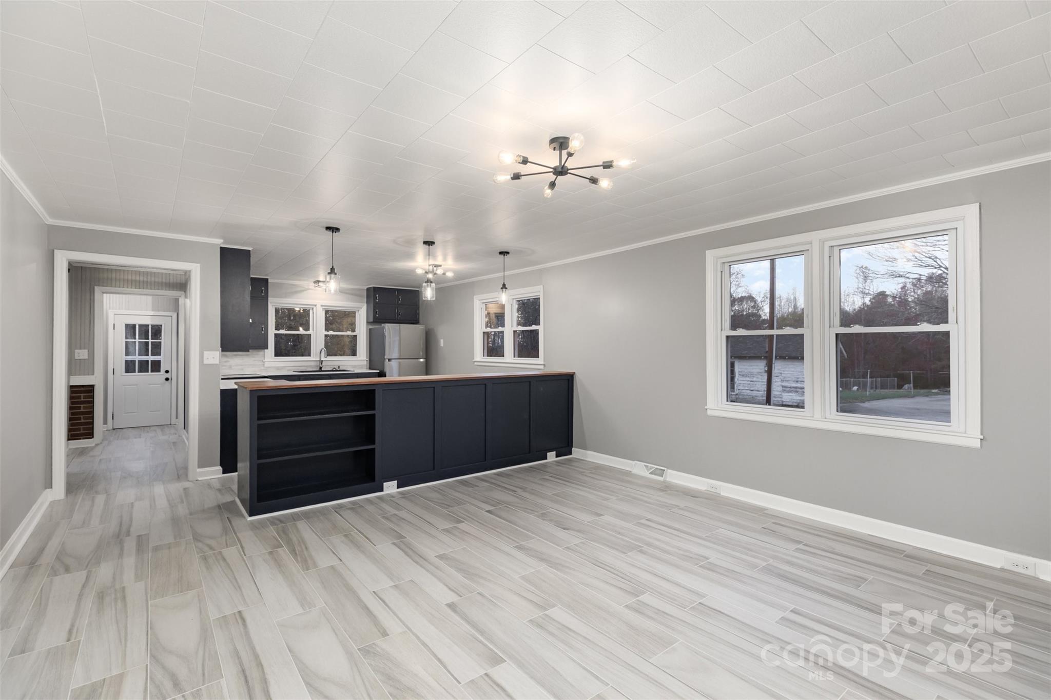 273 Stanley Spencer Mountain Road Gastonia, NC 28056 - Photo 6 of 17 a view of a kitchen with kitchen island wooden floor and window
