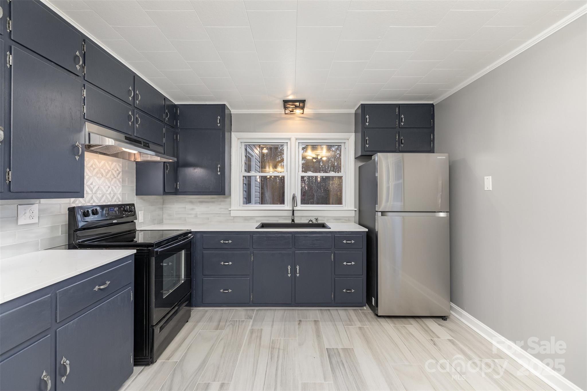 273 Stanley Spencer Mountain Road Gastonia, NC 28056 - Photo 7 of 17 a kitchen with granite countertop a refrigerator a sink a stove and wooden cabinets