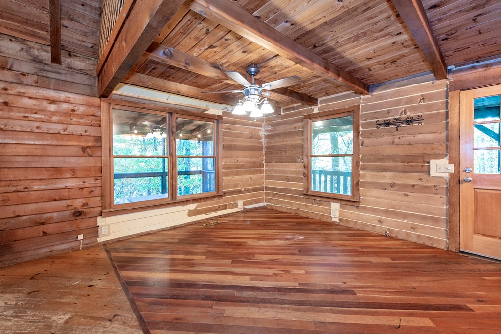 168 Burnt Mountain Cove Road Jasper, GA 30143 - Photo 14 of 53 a view of an empty room with wooden floor and a window