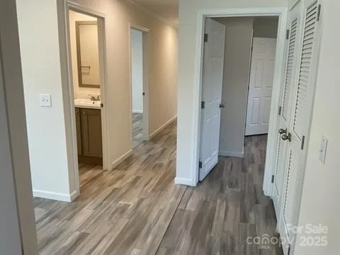 a view of a hallway with wooden floor and staircase