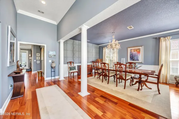a view of a a dining room with furniture window and wooden floor