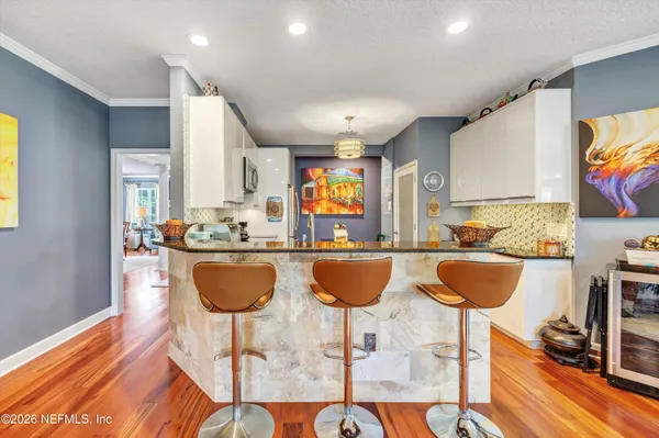 a kitchen with granite countertop a dining table chairs and a large window