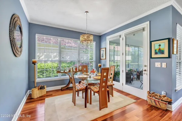 a dining room with furniture a chandelier and wooden floor