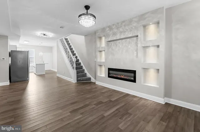 a view of a livingroom with wooden floor and staircase