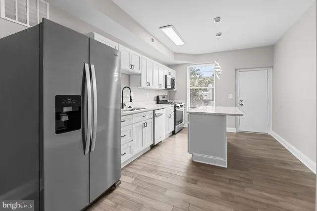 a kitchen with stainless steel appliances a refrigerator sink and cabinets