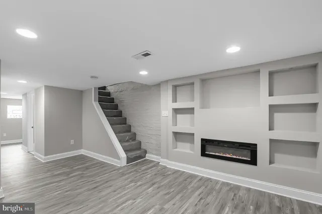 a view of a livingroom with wooden floor and staircase