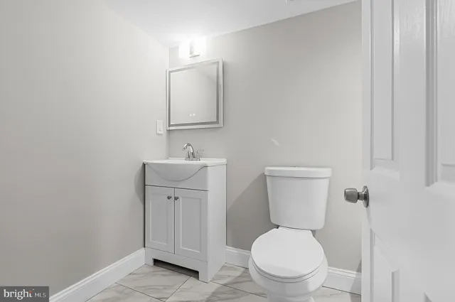 a bathroom with a toilet sink and mirror