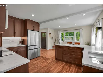 a kitchen with refrigerator cabinets and wooden floor