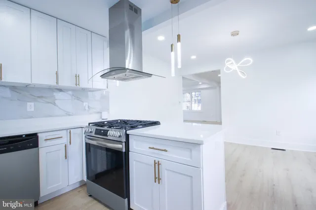 a kitchen with stainless steel appliances granite countertop a sink a stove and a refrigerator