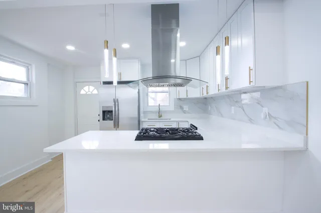 a kitchen with stainless steel appliances a refrigerator a sink and a stove