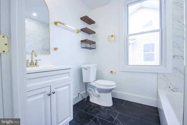 a white toilet sitting next to a bathroom sink