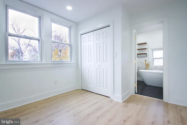 an empty room with windows and closet