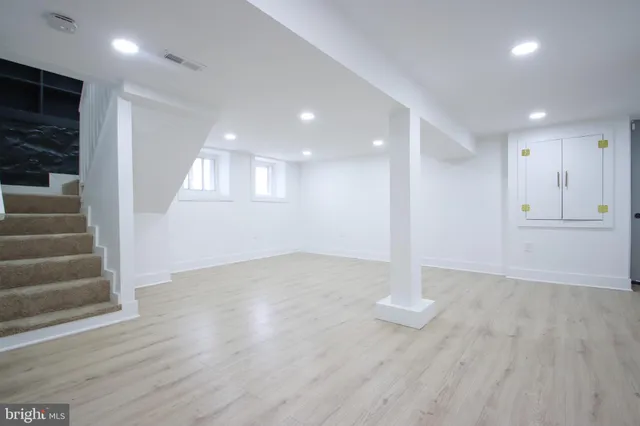 a view of a livingroom with wooden floor and staircase