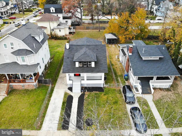 an aerial view of a house with swimming pool and large trees