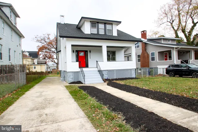 a front view of a house with a yard and trees