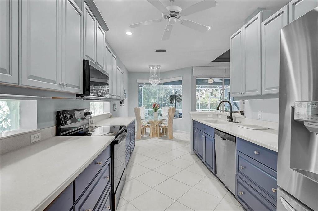 103 Bishopscourt Road Osprey, FL 34229 - Photo 12 of 55 a kitchen with stainless steel appliances kitchen island granite countertop a sink stove and cabinets