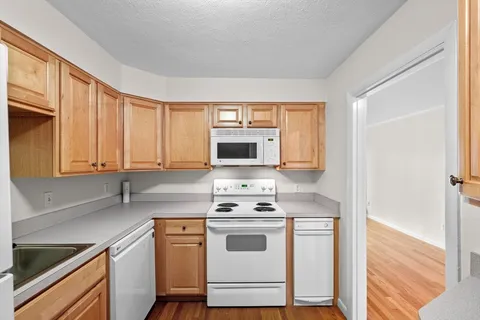 a kitchen with a white stove top oven and refrigerator